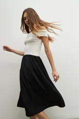 Vestido midi de corte recto, con top blanco de escote bardot y falda negra.