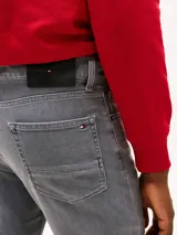 Pantalón jean slim gris con efecto desteñido y usado en la cintura. Confeccionado en tejido denim elástico de algodón. Cierre de cremallera con botón y diseño de cinco bolsillos. Incluye logo de Tommy Hilfiger bordado en el bolsillo trasero.