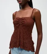 Blusa peplum de encaje marrón con breteles finos, escote cuadrado y busto fruncido.