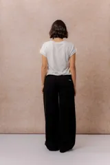 Pantalón de jean negro de corte wide leg, tiro alto y con costura vertical frontal.