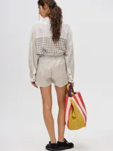 Short de corte boxy confeccionado en viscosa con estampado geométrico de estrellas en tonos rosados. Presenta una pretina elástica en color naranja y cordón de ajuste en color marrón.