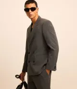 Blazer masculino de sastrería con corte boxy, escote en V, cierre frontal de doble abotonado y bolsillos funcionales. Confeccionado en tejido de poliviscosa con elastano, ofrece una estructura moderna y versátil.