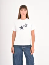Remera color gris topo con estampa frontal en blanco que incluye gráficos de llaveros y la inscripción "Lucky Charm".
