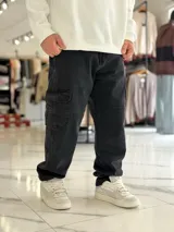 Pantalón cargo de jean azul con múltiples bolsillos en los laterales y diseño holgado.