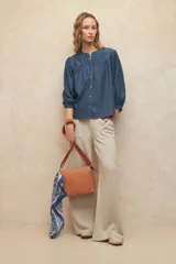 Bandolera color beige de cuero sintético texturizado, con correa desmontable y regulable. Tiene un compartimento principal con cierre y tres bolsillos internos adicionales.