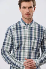 Camisa de manga larga de calce slim, con diseño a cuadros en tonos azul oscuro, verde y blanco. Presenta cuello camisero con botones y bolsillo ojal en el pecho con detalle bordado.
