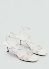 Sandalias de tacón kitten color blanco con tiras finas y cierre con hebilla en el tobillo.
