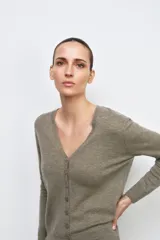 Chaqueta tipo cárdigan de lana, color beige, con escote en pico, manga larga y cierre frontal con botones.