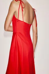 Vestido midi negro con cuello halter y falda acampanada con volumen.
