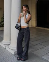 Pantalón de jean estilo wide leg con tiro bajo, en color negro lavado. Presenta un corte recto y holgado, con cierre frontal y bolsillos clásicos.
