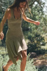 Vestido midi sin mangas, con escote redondo y diseño a rayas horizontales en color marrón y crudo. Presenta un corte asimétrico en la falda con un panel con vuelo y caída pronunciada en el bajo.