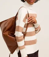 Suéter de punto pesado con cuello alto y mangas largas. Diseño a rayas horizontales en blanco y negro con textura acanalada.