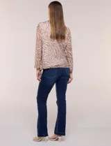 Cardigan abierto con blusa interior blanca, confeccionado en tejido de tul semitransparente con estampado animal print en tonos marrón y blanco, mangas 3/4 y escote redondo con detalles metálicos.