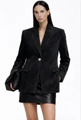 Blazer de gamuza negra con solapas clásicas, cierre frontal de un botón y bolsillos con solapa. Presenta un corte estructurado y elegante.