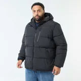 Campera acolchada tipo puffer color negro, con capucha fija, cierre frontal completo y bolsillos laterales y en el pecho con cierre.