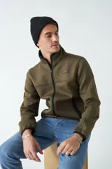 Campera verde militar con cuello alto y bolsillos laterales con cierre.