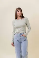 Remera de manga larga con escote redondo, confeccionada en tejido suave y elástico con calce al cuerpo.