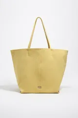 Bolso shopper grande Bimba Y Lola de color amarillo, con exterior de nylon, asas de hombro y detalles en piel. Cuenta con cierre de mosquetón y logo metálico de la marca en la parte frontal.
