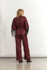 Mono largo de seda color celeste, con escote en V cruzado, mangas cortas amplias con flecos negros y cintura elastizada.