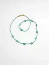 Collar corto de cuentas de piedra en tonos turquesa y celeste, con diseño de piedras facetadas y cuentas irregulares intercaladas.