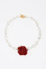 Collar de perlas barrocas blancas con dije central de rosa roja en resina y cierre tipo toggle dorado.