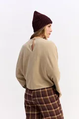 Blusa de corte relajado y fit holgado, con mangas largas amplias y textura sutil. Presenta un diseño minimalista con caída suave.