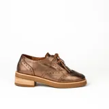 Zapato acordonado estilo oxford de cuero vacuno en color plateado metalizado, con diseño brogue, suela de goma y taco de madera.