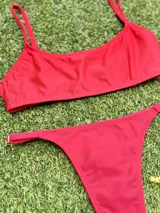 Conjunto de bikini rojo, con corpiño tipo top de breteles finos y bombacha colaless regulable.