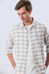 Camisa de manga larga de lino y algodón, con estampado a cuadros en tonos beige, blanco y celeste, cuello camisero y cierre frontal con botones.