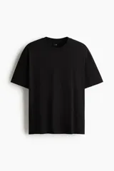 Remera negra de punto de algodón de peso medio, cuello redondo ribeteado y hombros caídos con corte relajado.