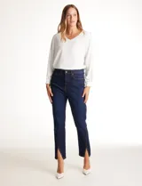 Jean skinny de tiro alto, color azul oscuro, con cierre frontal y botón. Presenta un diseño ajustado con tajos frontales en el ruedo y bolsillos funcionales.