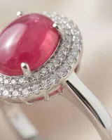 Anillo de plata 925 con piedra central ovalada de raíz de rubí en tono rojizo, rodeada por un halo de circonias brillantes.