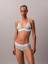 Bralette de triángulo Calvin Klein, confeccionado en una mezcla de algodón y modal. Presenta copas ligeramente forradas sin aros, tirantes ajustables y la icónica banda elástica con el logo de la marca en contraste.