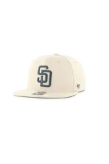 Gorra tipo snapback con corona estructurada y visera plana, color beige con el logo de los San Diego Padres bordado en relieve en color azul oscuro en el frente. Cuenta con el logo de la marca 47 en el lateral.
