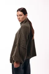 Sweater de punto grueso con cuello alto, diseño de hombros caídos y mangas amplias con puños acanalados.