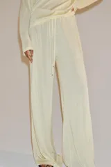 Pantalón de corte recto y tiro medio, confeccionado en tejido fluido de lyocell. Presenta cintura elástica con cordón ajustable.