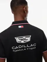 Chomba negra de algodón elástico con cuello polo, cartera de dos botones y mangas cortas. Presenta detalles de ribetes con diseño Global Stripe en el cuello y los puños, además de los logotipos de Tommy Hilfiger, TH x Cadillac Formula 1 Team, Pirelli y el número 11 en las mangas y el pecho.