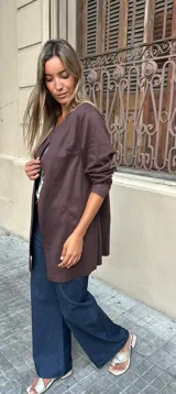 Chaqueta abierta de corte recto y largo medio, color marrón, con mangas largas y bolsillos frontales aplicados.