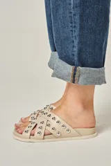 Sandalias de cuero vacuno en color natural, con diseño de tiras entrelazadas decoradas con tachas metálicas redondas y suela anatómica de goma.