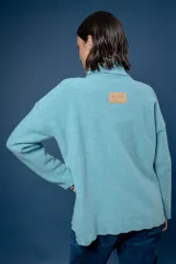 Buzo de cuello alto tejido en lana, con diseño de ochos en el centro y mangas largas con hombros caídos.