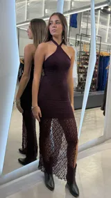 Vestido largo bordó de encaje, con escote halter y diseño ajustado al cuerpo que se transparenta en la parte inferior.