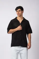 Camisa de manga corta tejida en algodón con diseño calado, cuello tipo bowling y cierre frontal con botones al tono.