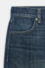 Jeans de tiro bajo con corte loose leg y largo tobillero. Presenta diseño de cinco bolsillos, cierre frontal con cremallera y botón, y acabado con efecto lavado.