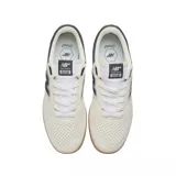 Championes New Balance NM508RDO color crema con detalles en negro y suela marrón.