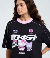 Remera de algodón negra con cuello redondo en color rosa, manga corta y diseño estilo racing. Presenta estampado frontal con personajes de Hello Kitty y Kuromi, junto con tipografía japonesa y detalles gráficos.