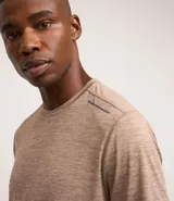 Remera deportiva masculina de manga corta con cuello redondo, confeccionada en tejido técnico con tecnología Dry para mayor transpirabilidad. Presenta detalles reflectantes en los hombros y un diseño liso en color verde melange.