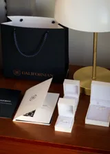 Conjunto de joyería de tres piezas en plata 925 y zirconias, compuesto por una pulsera con cadena y zirconias colgantes, un anillo medio sin fin con zirconias y un anillo solitario con zirconias en corte gota y pavé lateral.