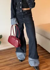 Pantalon de jean azul oscuro con costuras en contraste, corte wide leg y ruedo con doblez ancho en tono denim claro.