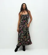 Vestido midi de corte evasé confeccionado en chiffon, con estampado floral sobre fondo negro, escote cuadrado y breteles finos.