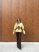 Sweater tejido con escote en V y calce relajado, con diseño de rombos en colores bordó y celeste.